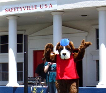 Safetyville mascot standing in front of a Safetyville building