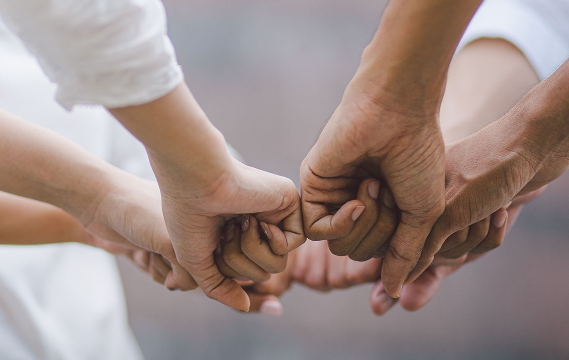 an image hands coming together fist bumping as a team