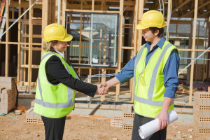 civil engineer and worker shaking hands at the construction site